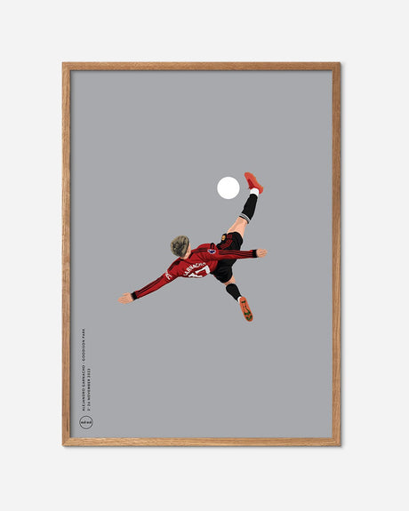 Fodbold plakat af spiller i rødt trøje udfører saksespark, minimalistisk design med egetræsramme