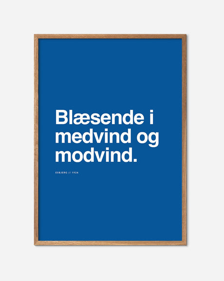 Blå Esbjerg fodbold plakat med mottoet 'Blæsende i medvind og modvind' i egetræsramme