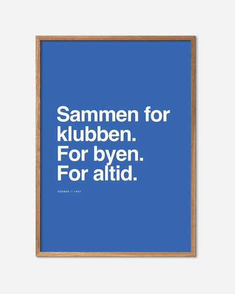Blå fodbold plakat med Odense motto i hvid tekst og egetræsramme, moderne fodboldkunst.