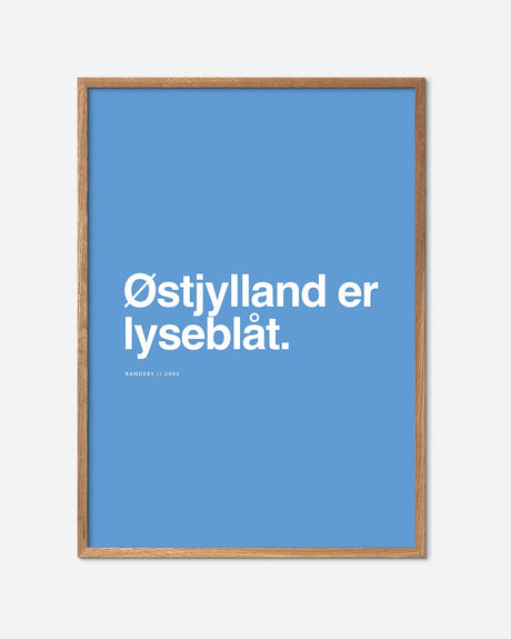 Lyseblå fodbold plakat med teksten 'Østjylland er lyseblåt' i egetræsramme