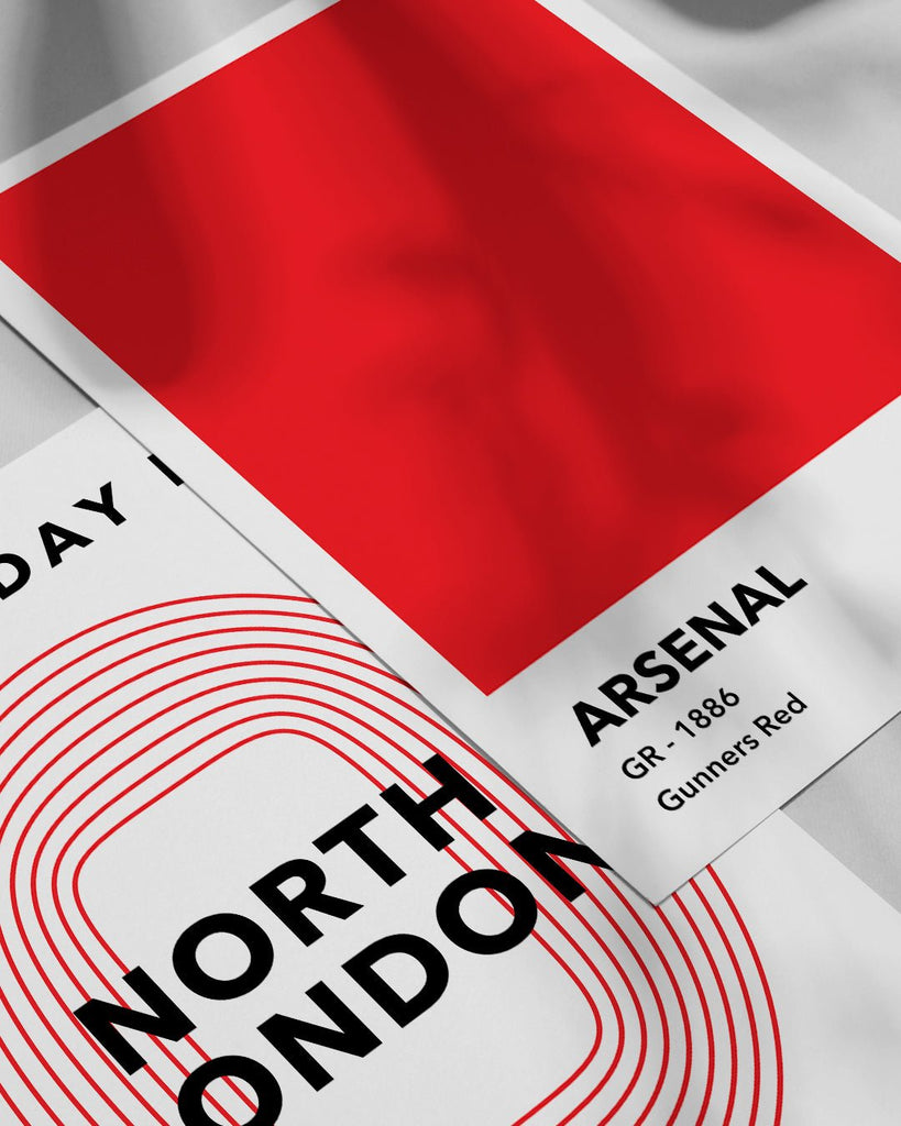 En Arsenal F.C. fodbold plakat med deres røde farve fra Colors kollektionen ved siden af en anden plakat - Olé Olé