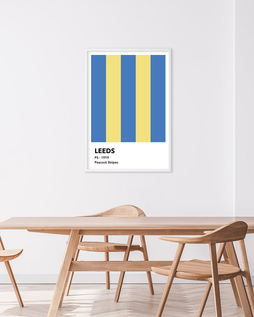 En Leeds United F.C. fodbold plakat med deres påfugle striber fra Colors kollektionen hængende i en stue - Olé Olé