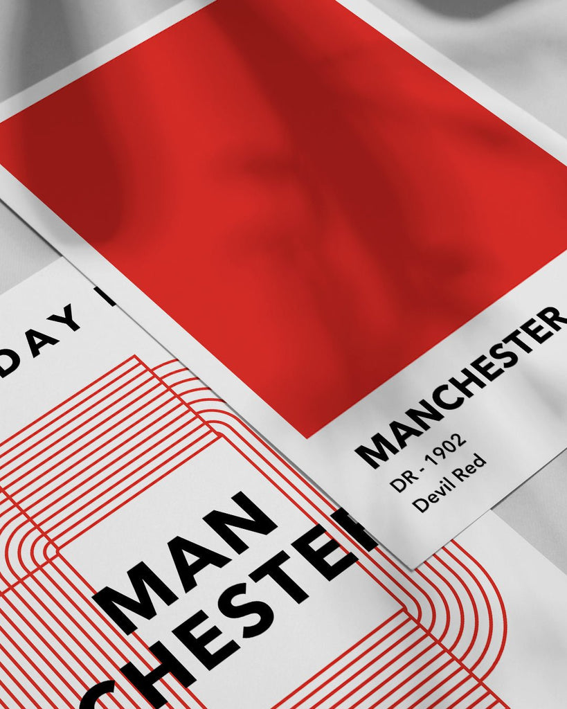 En Manchester United fodbold plakat med deres røde farve fra Colors kollektionen ved siden af en anden plakat - Olé Olé