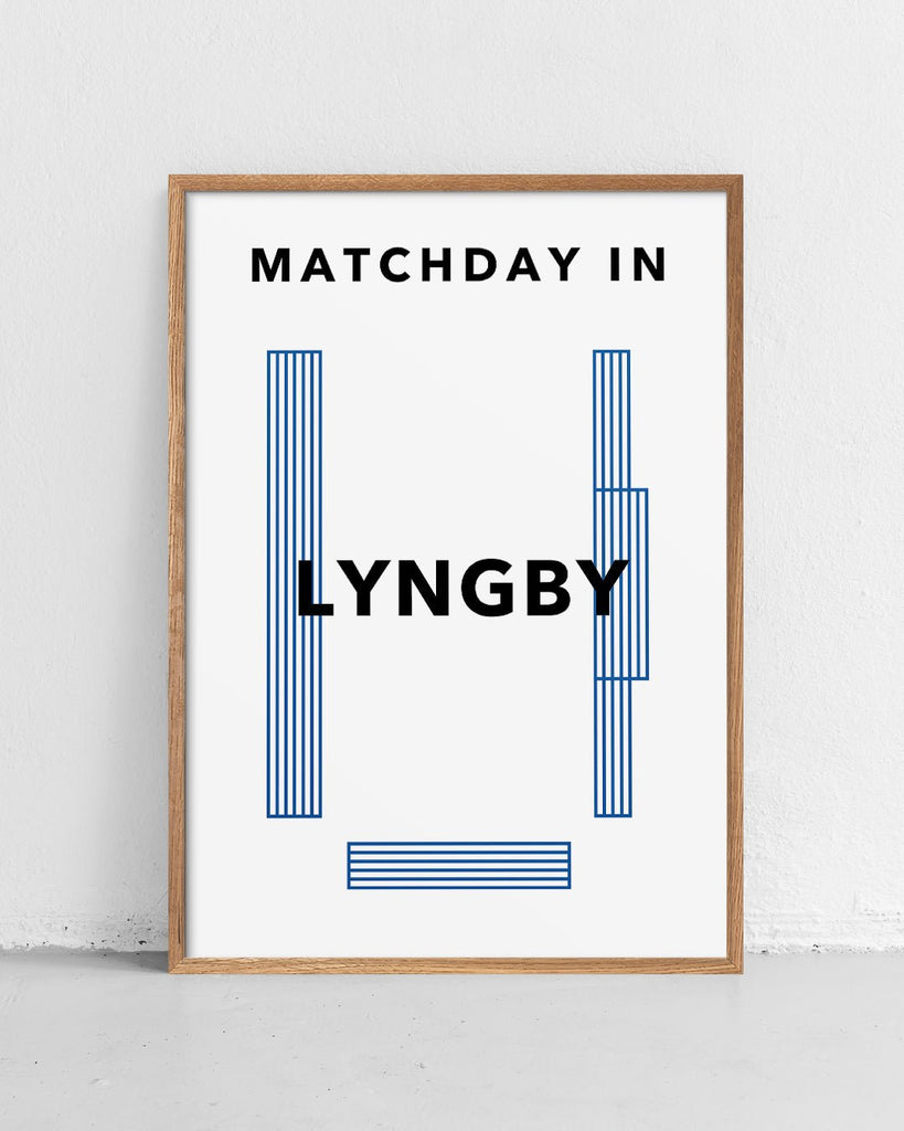En Lyngby B.K. fodbold plakat med Lyngby Stadion fra Matchday kollektionen stående på et gulv - Olé Olé