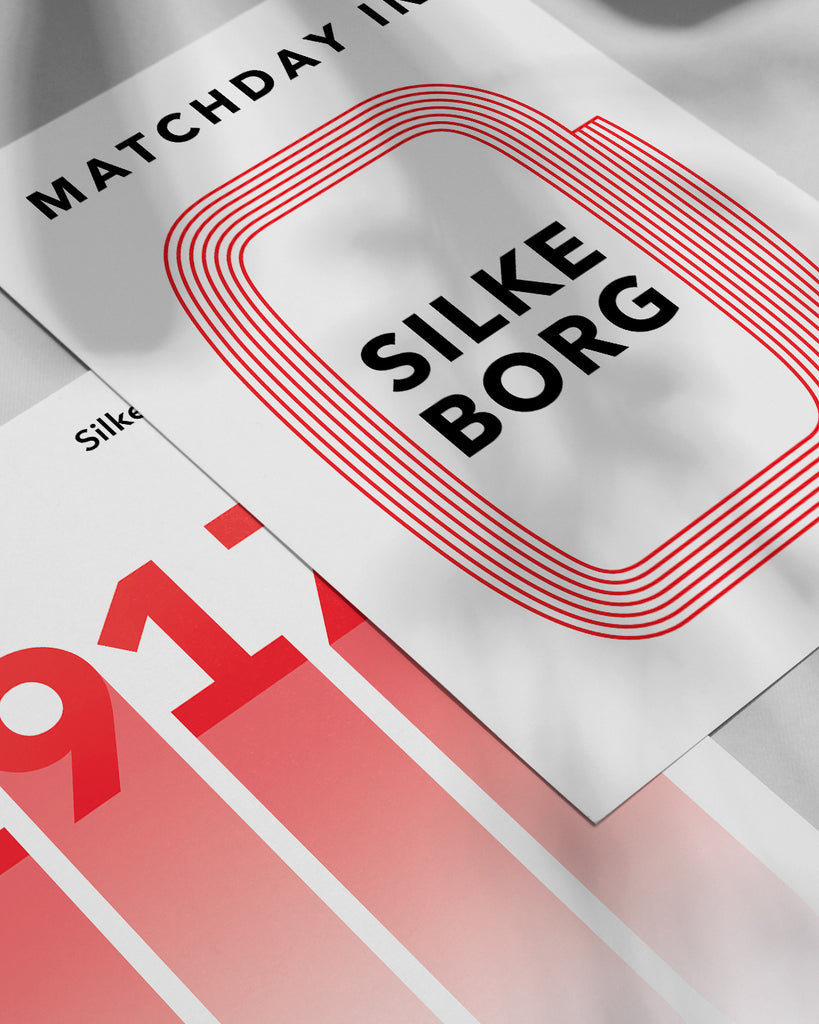 En Silkeborg I.F. fodbold plakat med Jyske Park fra Matchday kollektionen ved siden af en anden plakat - Olé Olé