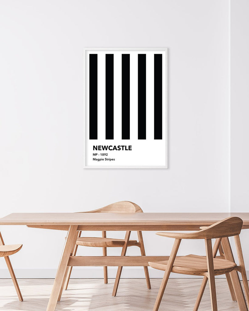 En Newcastle F.C. fodbold plakat med deres sorte og hvide striber fra Colors kollektionen hængende i en stue - Olé Olé