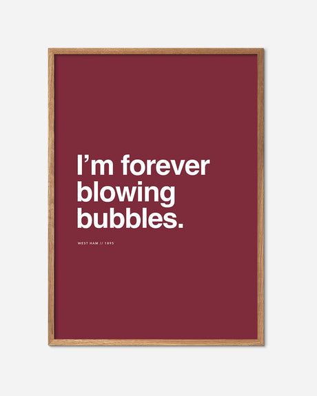West Ham fodbold plakat med teksten 'I'm forever blowing bubbles' på vinrød baggrund i egetræsramme