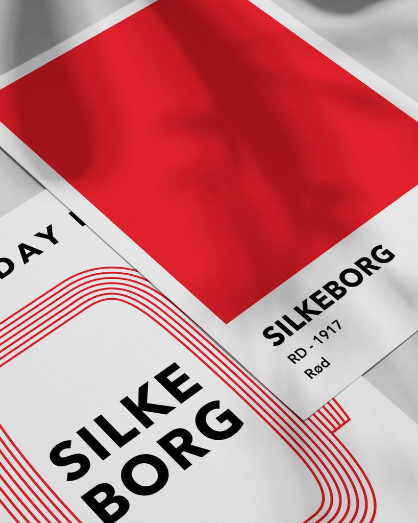 En Silkeborg I.F. fodbold plakat med deres røde farve fra Colors kollektionen ved siden af en anden plakat - Olé Olé